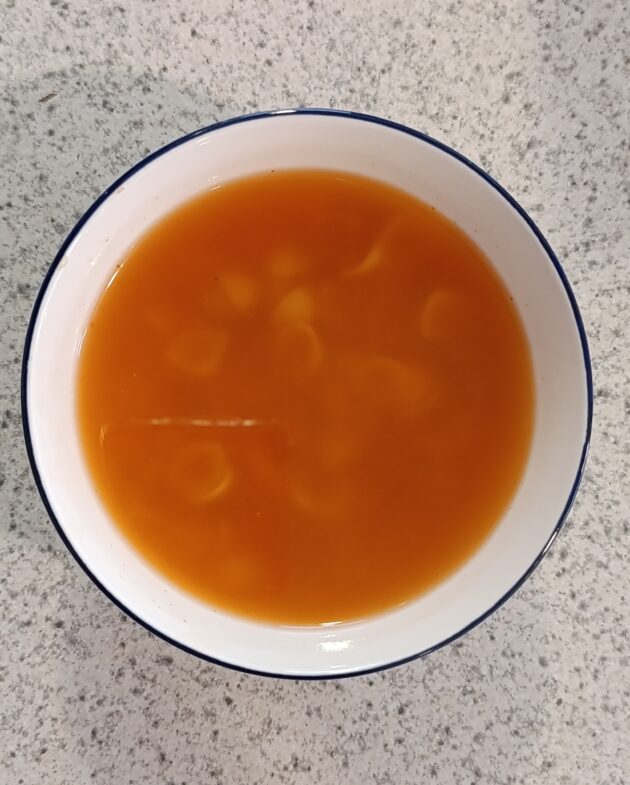 Tazón de sopa aguada de pasta con caldillo de jitomate rojo