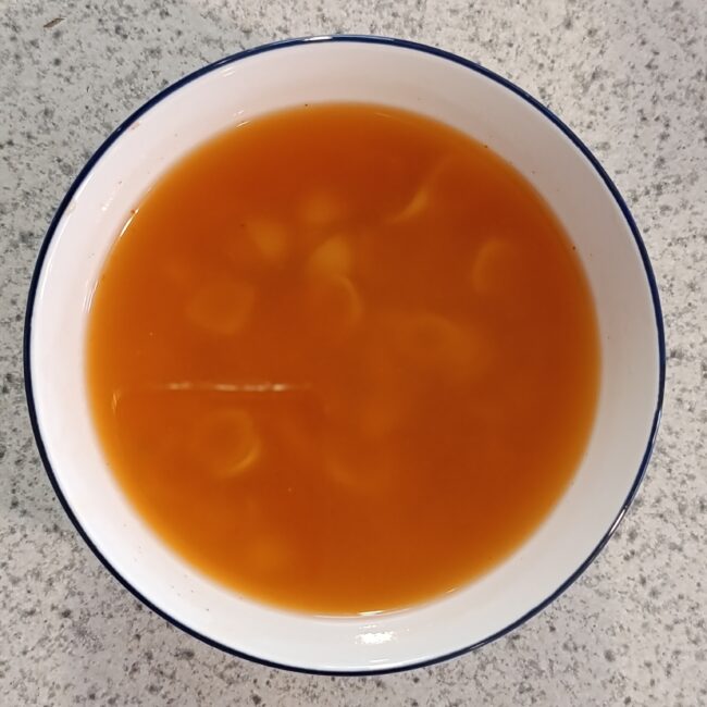 Tazón de sopa aguada de pasta con caldillo de jitomate rojo