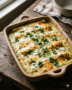 Plato de cerámica rectangular con enchiladas suizas tradicionales doradas al horno, cubiertas con salsa verde cremosa y queso fundido.