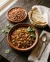 Plato hondo con picadillo de res con papa caldoso, acompañado de cubitos de zanahoria y servido con tortillas de maíz.
